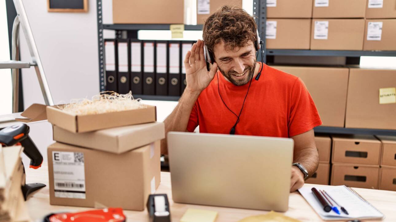 young-hispanic-call-center-agent-man-working-warehouse-smiling-with-hand-ear-listening-hearing-rumor-gossip-deafness-concept