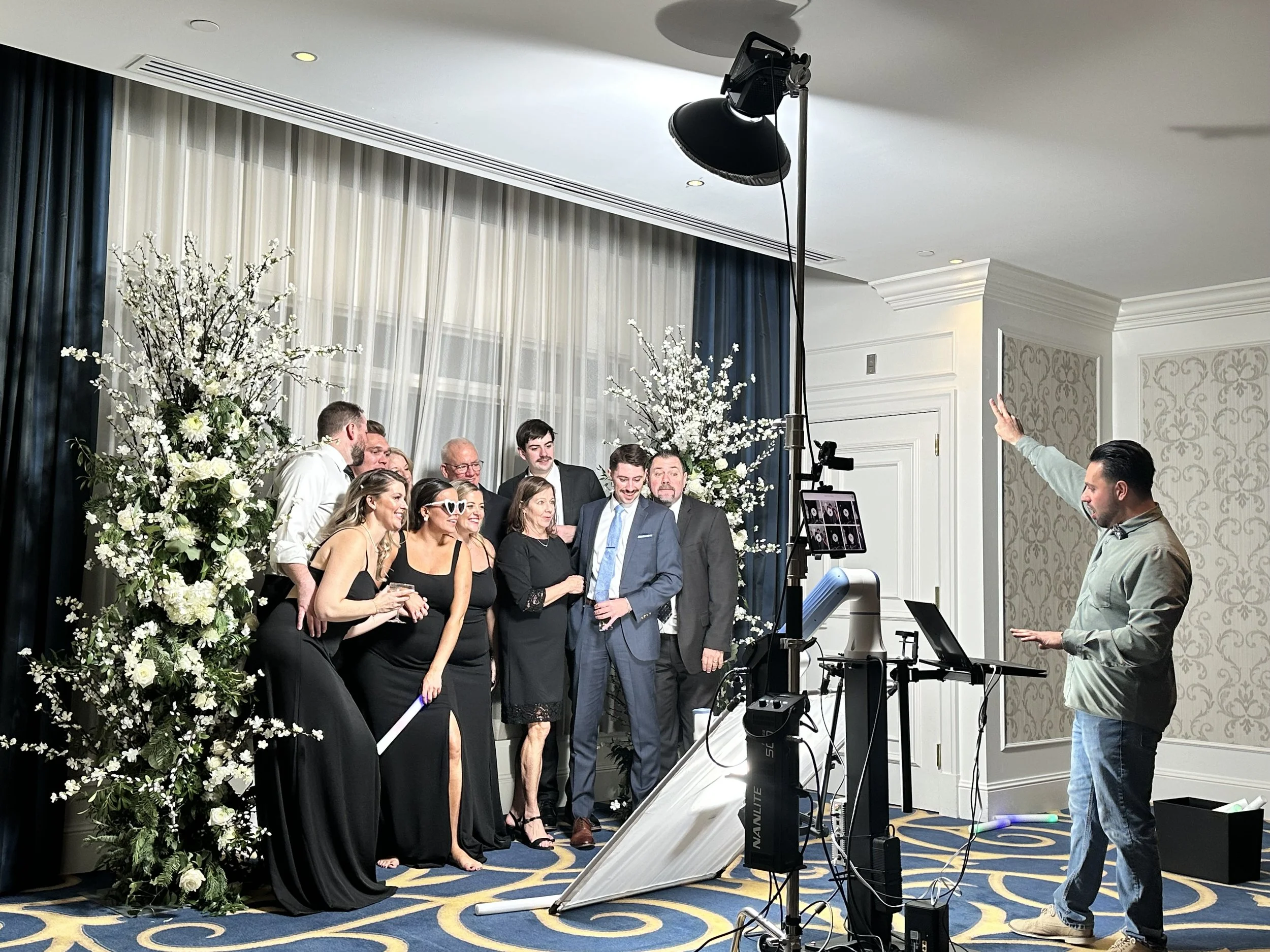 wedding-photo-booth-guests-in-formal-attire-pose-with-floral-backdrop